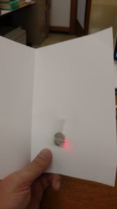 LED pushed through card holes with battery attached.